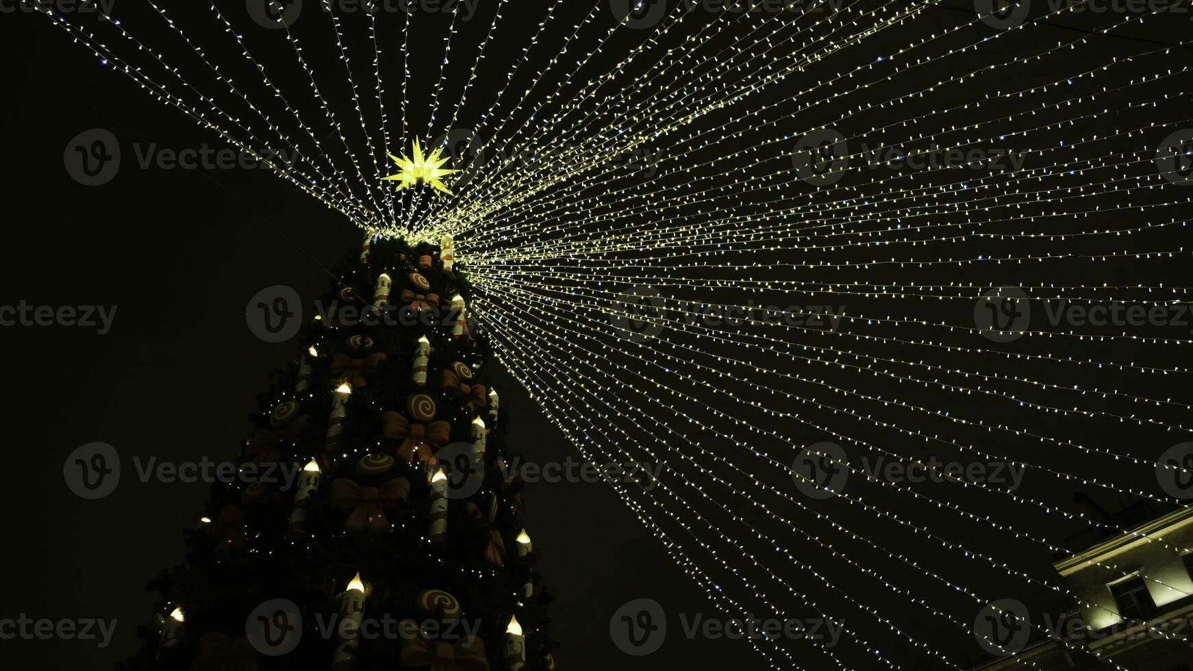 magnifique ville Noël arbre avec guirlandes sur Contexte de foncé nuit ciel. concept. magnifique brillant Noël arbre avec guirlandes sur nuageux hiver journée photo