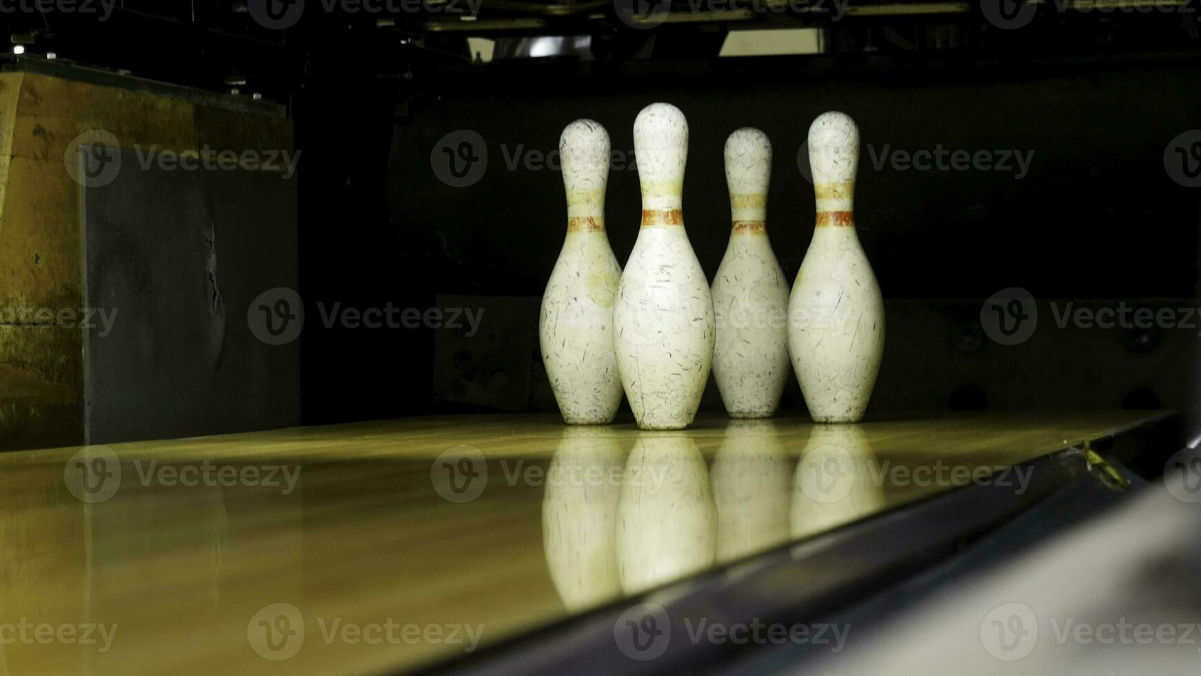 vert Balle échoue à frappé le jeu de quilles sur le en jouant champ, activité concept. médias. proche en haut pour nombreuses vieux blanc épingles permanent sur le en bois ruelle pendant le jeu. photo