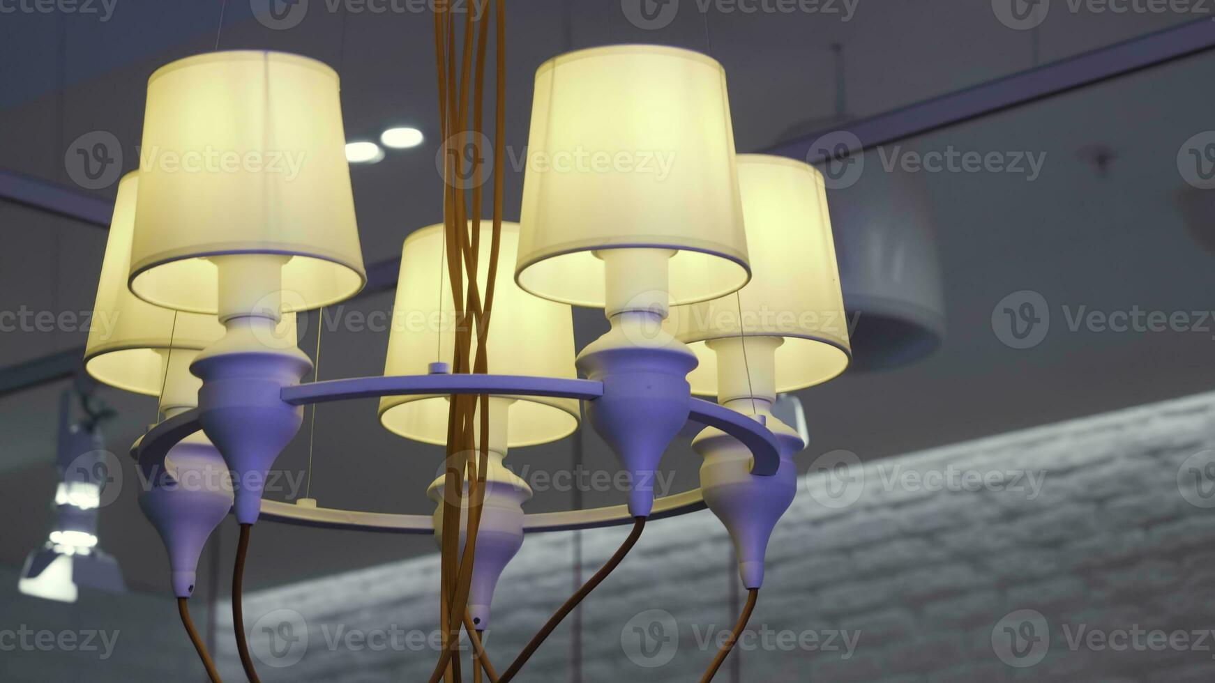 proche en haut de lustre pendaison sur blanc plafond Contexte. hdr. inhabituel pendaison lampe avec Orange fils, violet métal jante et beige luminaires. photo