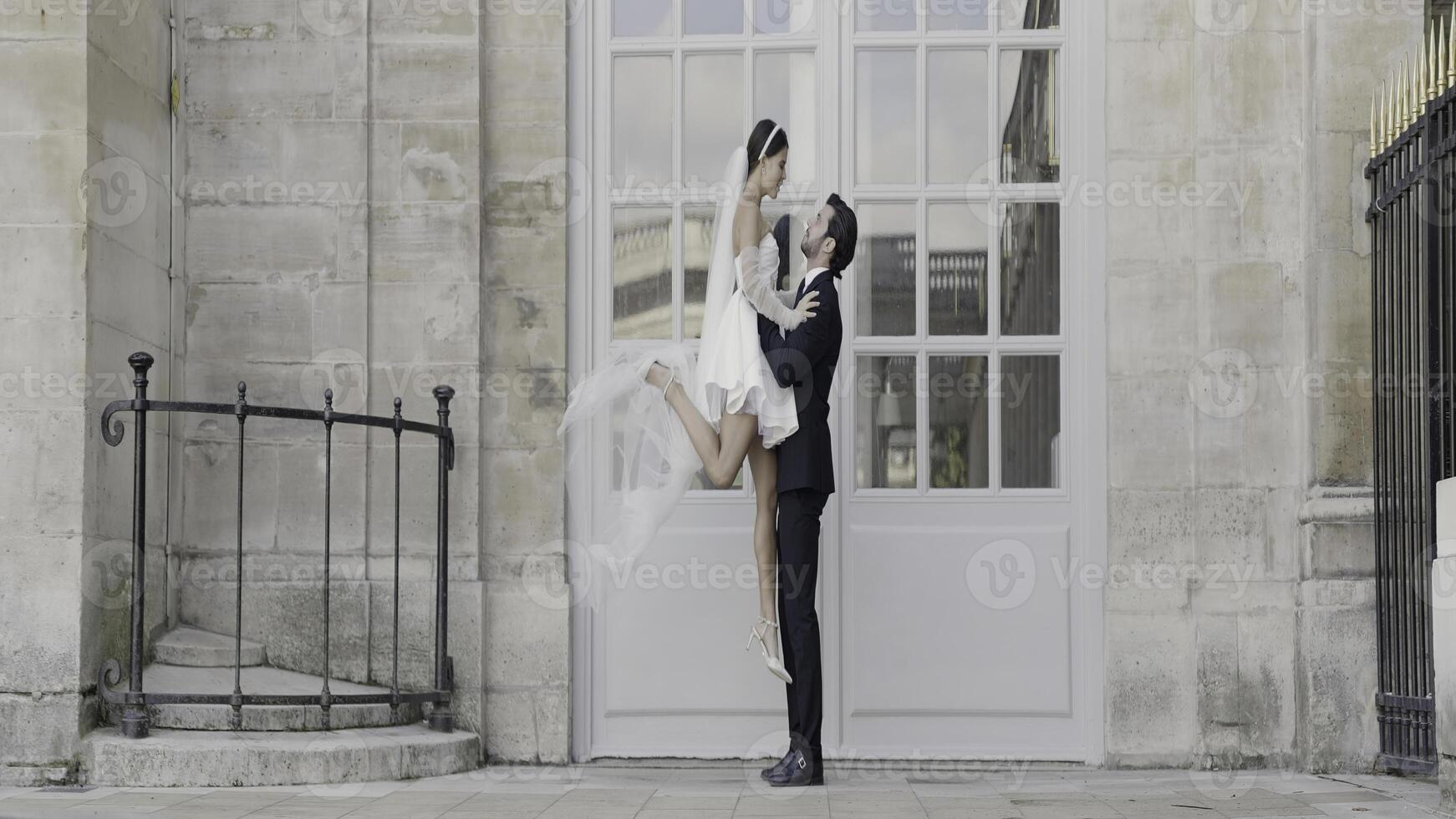 magnifique Date photo tirer. action.a Jeune fille dans une court robe et une homme levage sa et séance dans de face de le architecture.