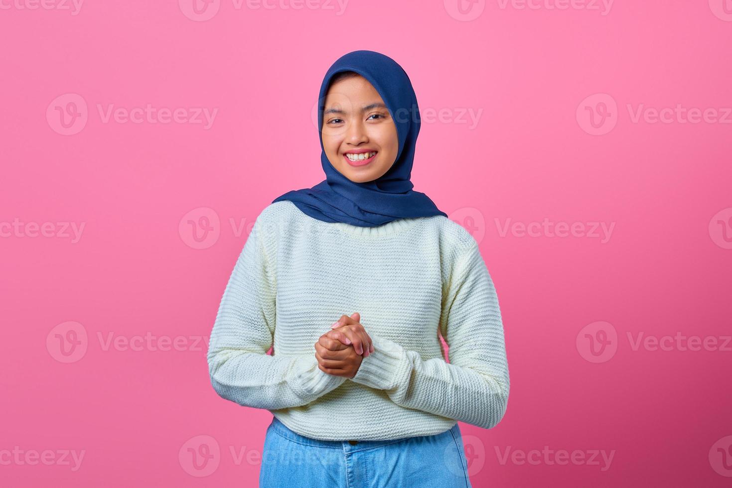 portrait de belle femme asiatique souriante avec la main ensemble sur fond bleu photo