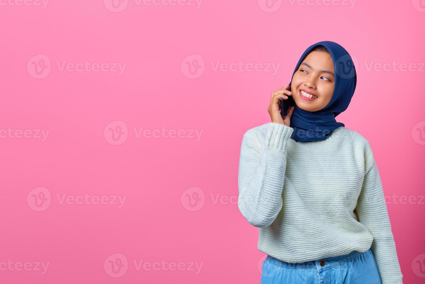 portrait d'une femme asiatique séduisante parlant sur un smartphone et ayant l'air heureux photo