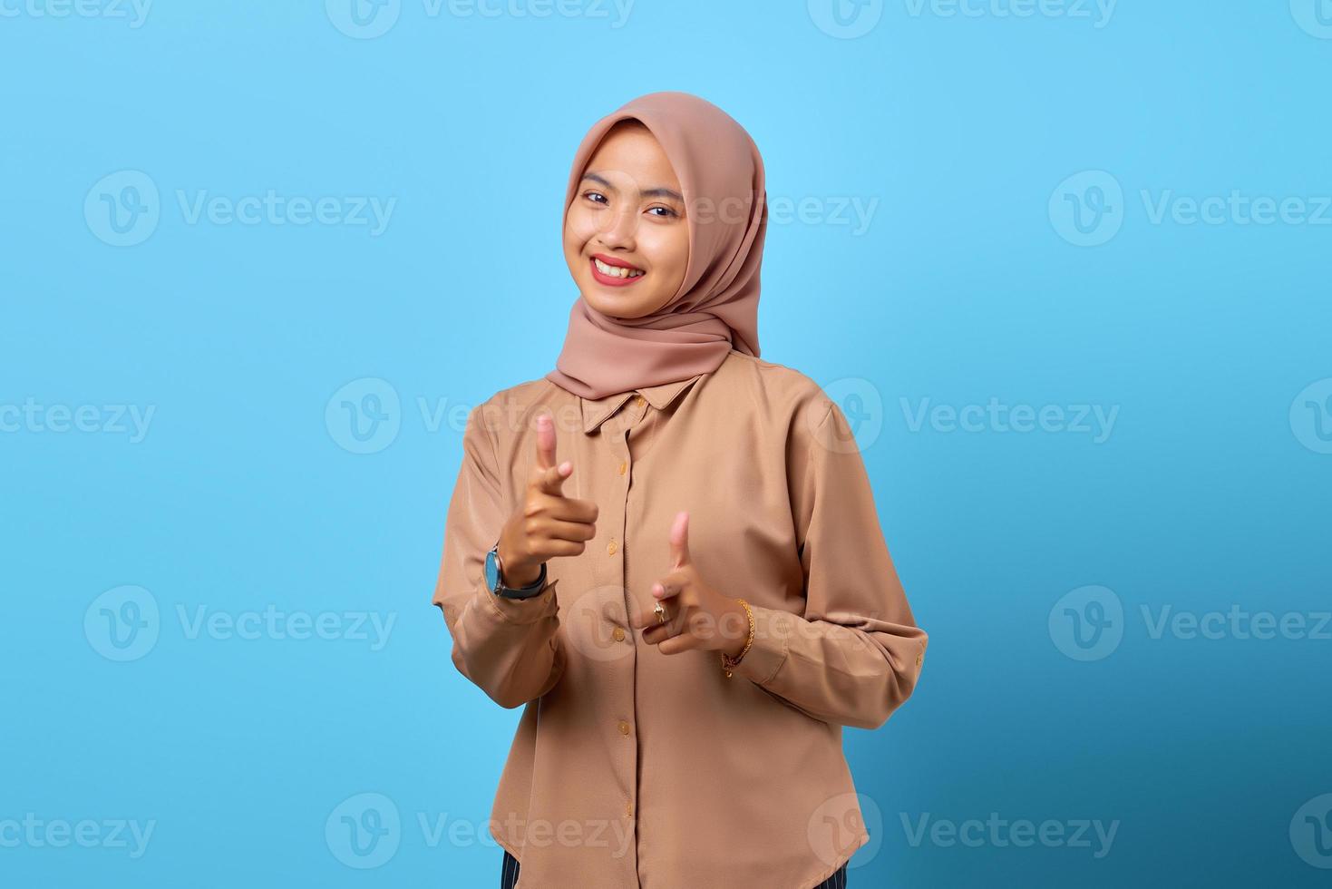 Portrait d'une jeune femme asiatique joyeuse et excitée pointant vers la caméra avec les mains du doigt photo