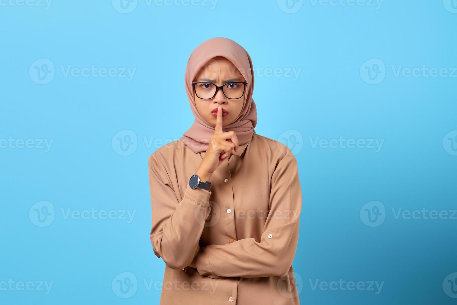 portrait de jeune femme asiatique fait un geste de silence avec les mains des doigts photo