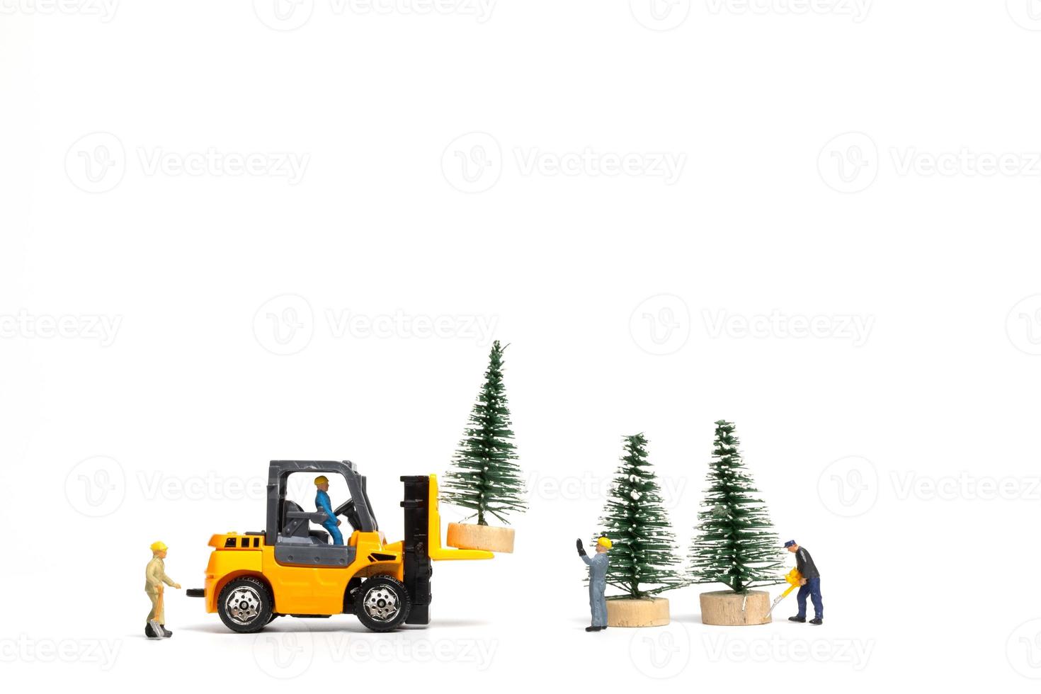 personnes miniatures, travailleur préparant l'arbre de Noël sur fond blanc photo