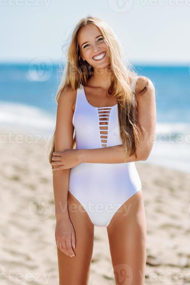 femme blonde avec un beau corps en maillot de bain sur une plage tropicale photo