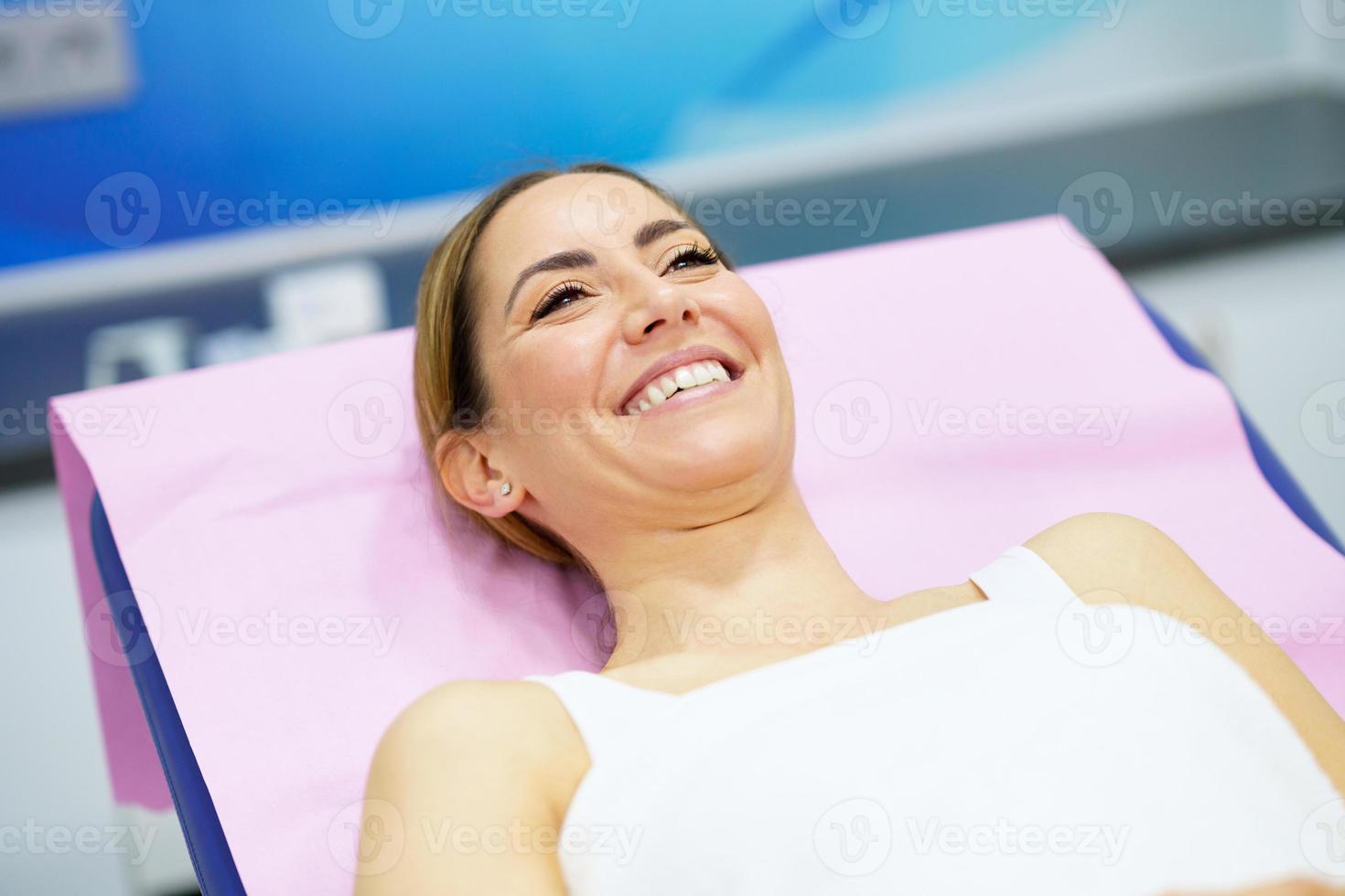 femme d'âge moyen allongée sur la civière dans une clinique esthétique. photo