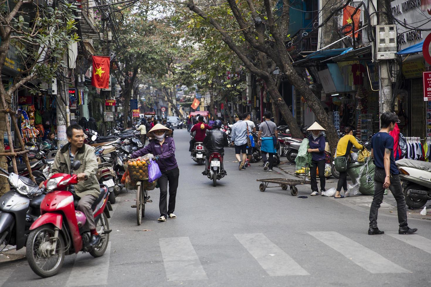 hanoi, vietnam, 2 mars 2017 - personnes non identifiées dans la rue de hanoi, vietnam. à hanoi, les motos ont dépassé les vélos comme principal moyen de transport. photo