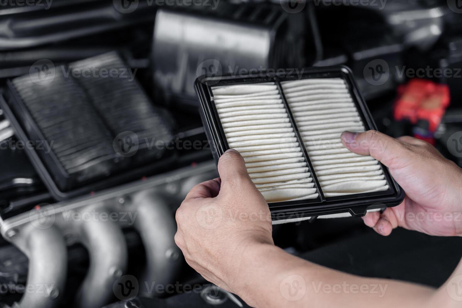 main un homme tenant une nouvelle partie du filtre à air du changement de moteur de voiture et vérification de la voiture dans la salle des machines concept de service de voiture de base photo