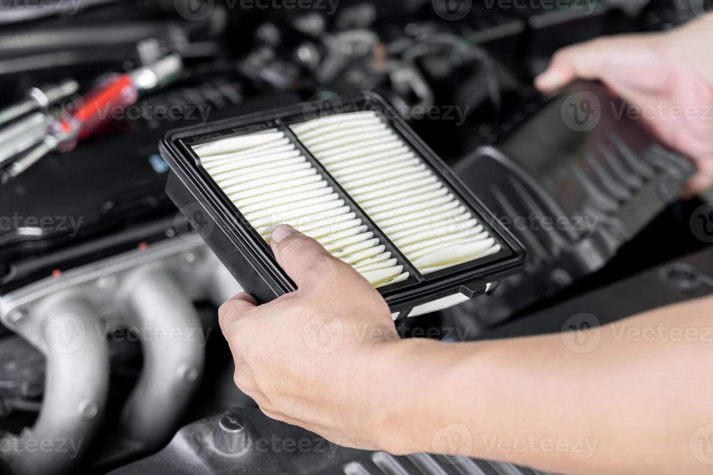 un service homme remplacer le vieux moteur air filtre par rapport à le Nouveau un dans moteur pièce Accueil un service voiture concept photo