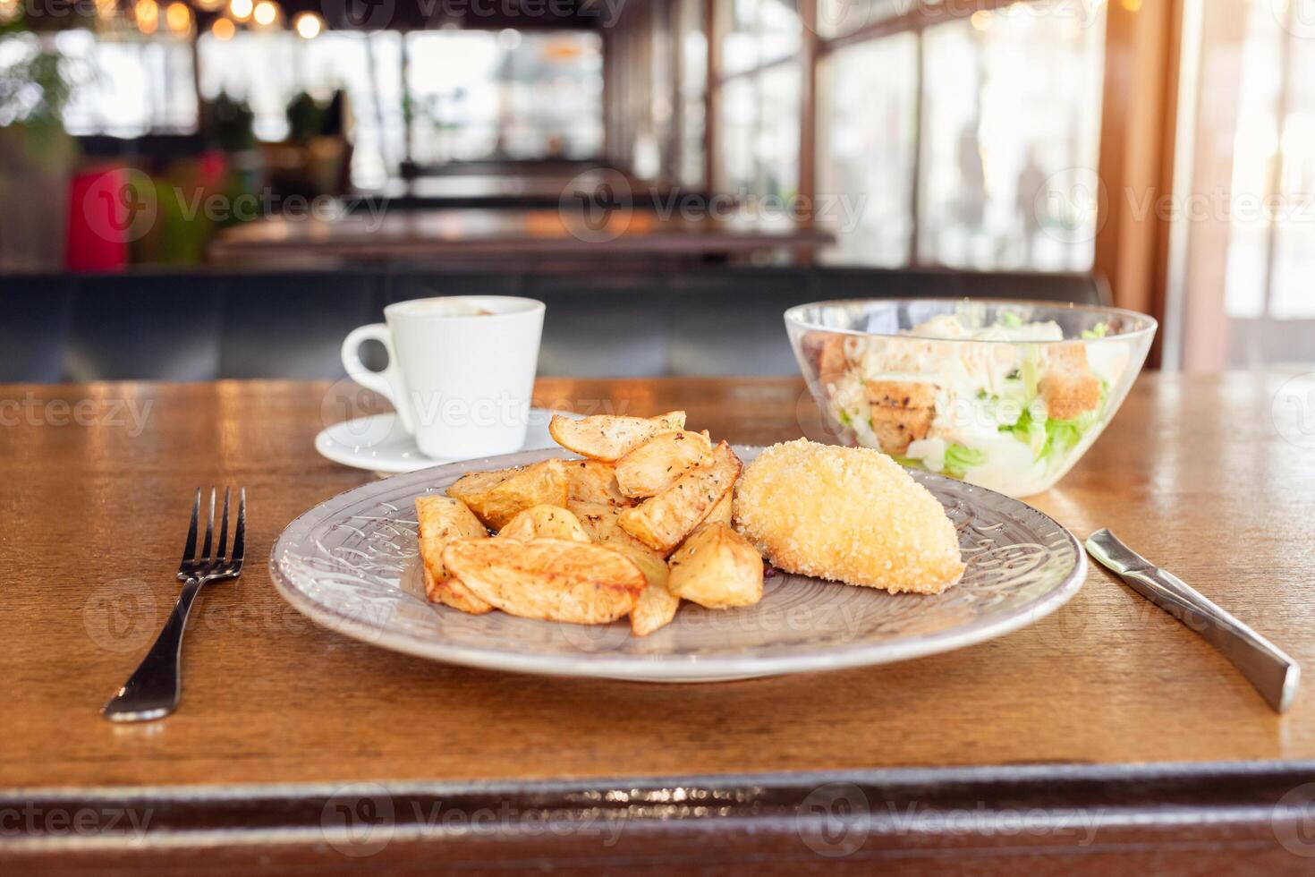 petit-déjeuner, dîner, le déjeuner dans une restaurant, café. cuit patates avec Boulettes de viande, César salade, café américain. intervieweur, délicieux nourriture, grand les fenêtres, Naturel lumière du soleil. flou Contexte photo