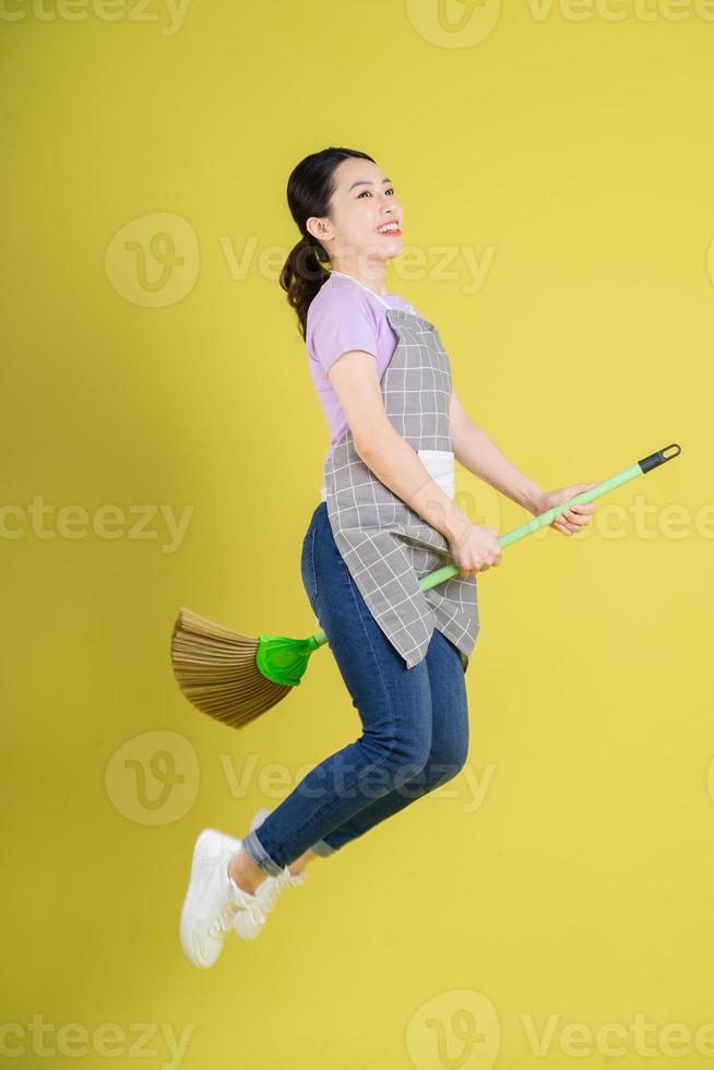 jeune femme au foyer asiatique posant sur fond jaune photo