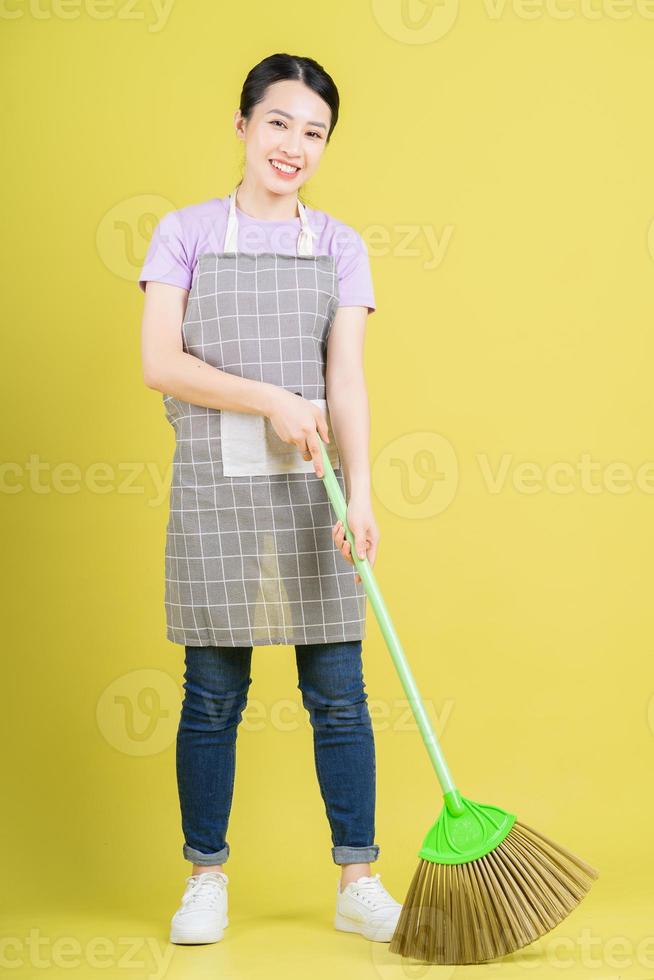 jeune femme au foyer asiatique posant sur fond jaune photo