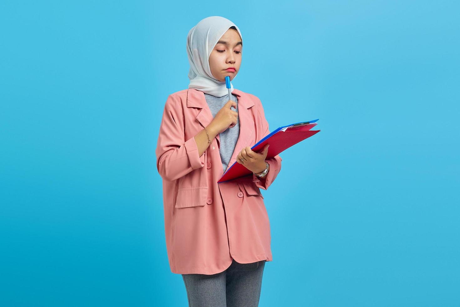 Jeune femme asiatique concentrée sur l'écriture de notes de planification de la stratégie de création sur fond jaune photo