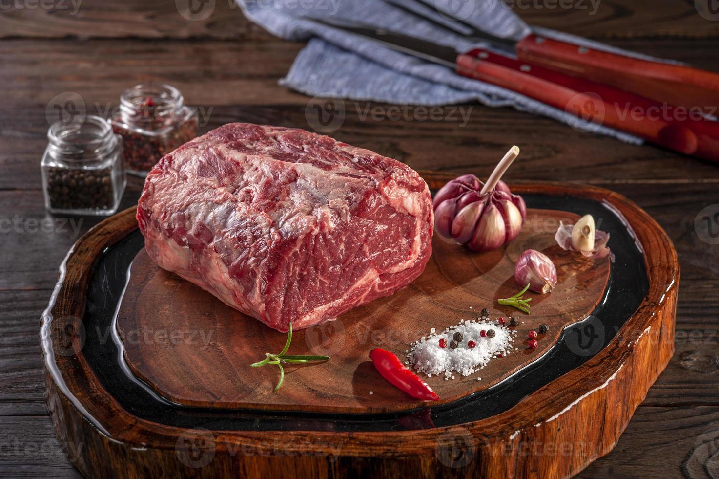 entrecôte de boeuf crue sur une planche à découper en bois avec des épices. photo