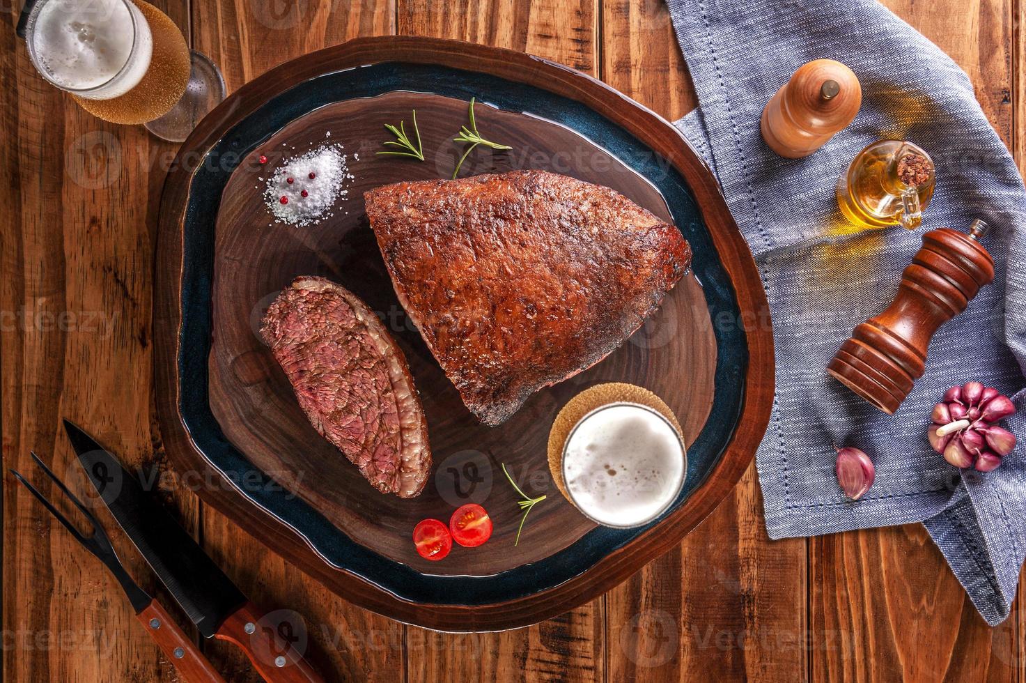 rumsteck grillé avec deux verres de bière sur une planche à découper en bois. viande de boeuf en marbre - picanha brésilien - vue de dessus. photo