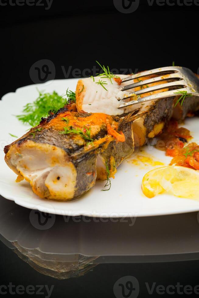 poisson cuit avec épices et des légumes dans le four. photo