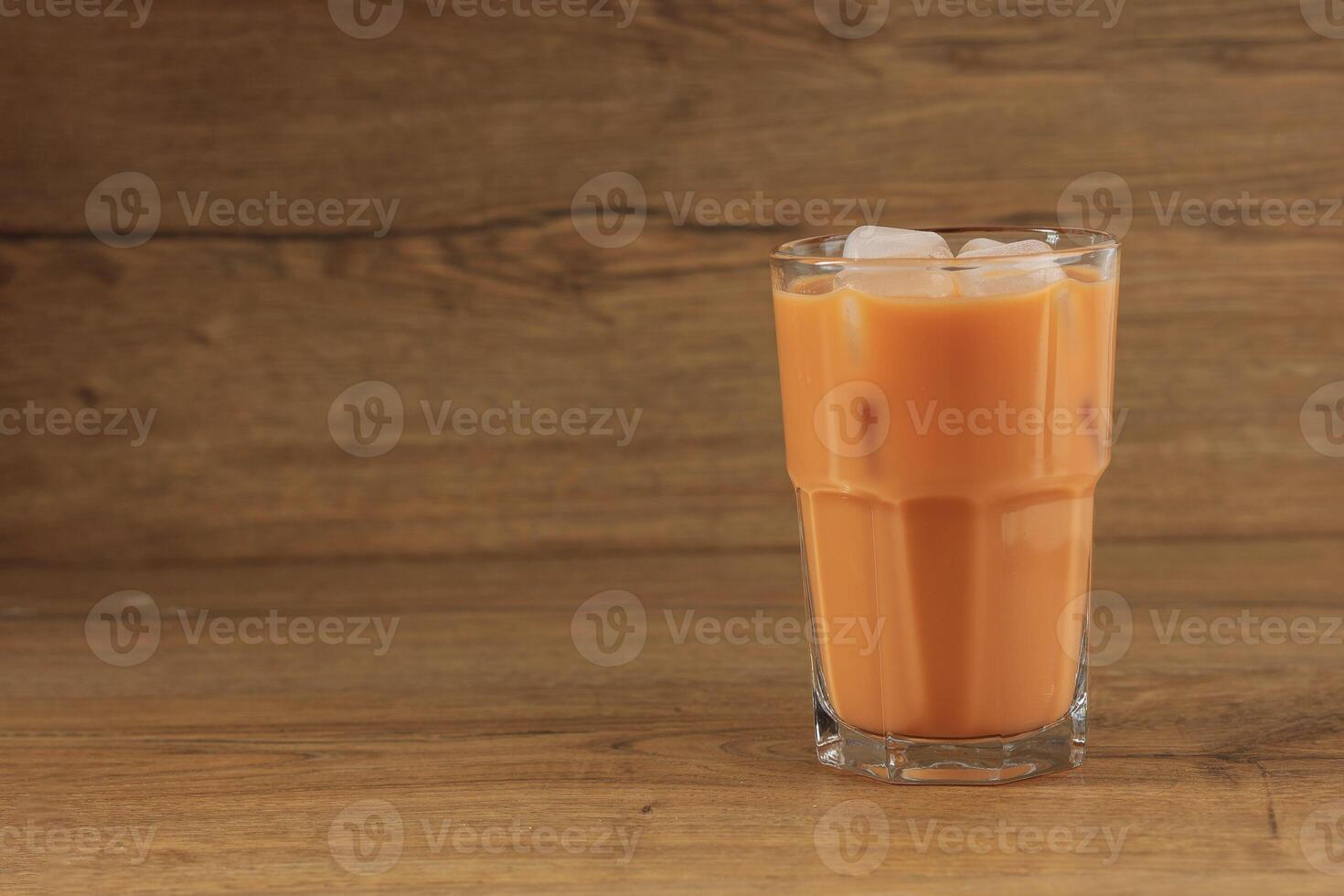 une verre de la glace thaïlandais Lait thé sur en bois table photo