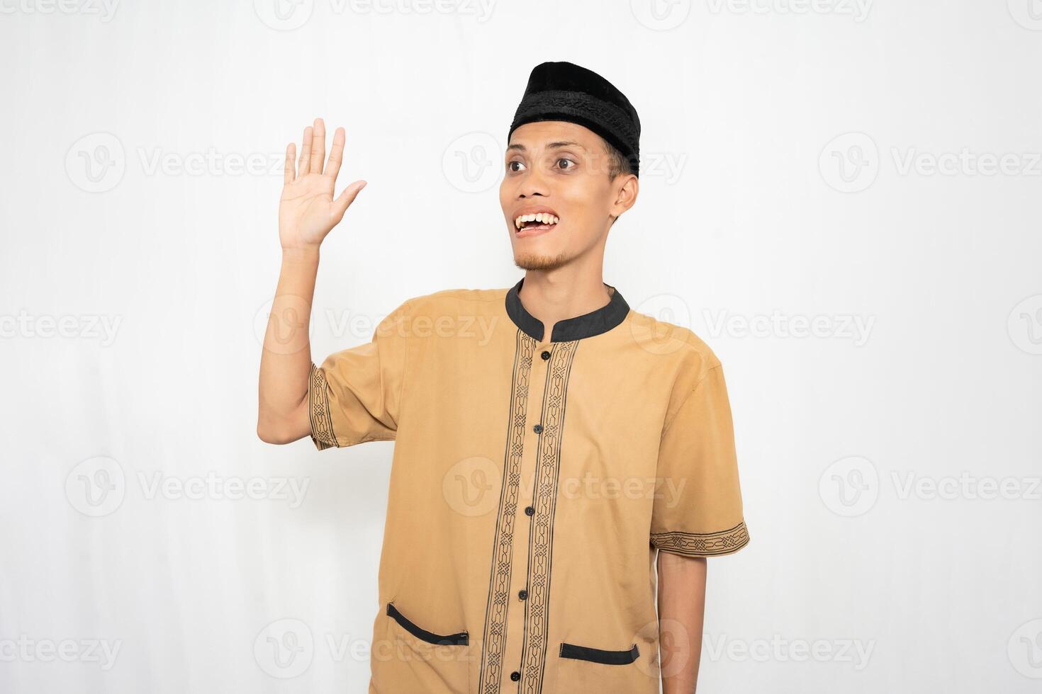 asiatique musulman homme portant marron musulman vêtements donne une salutation geste à invités ou amis. isolé blanc Contexte. photo