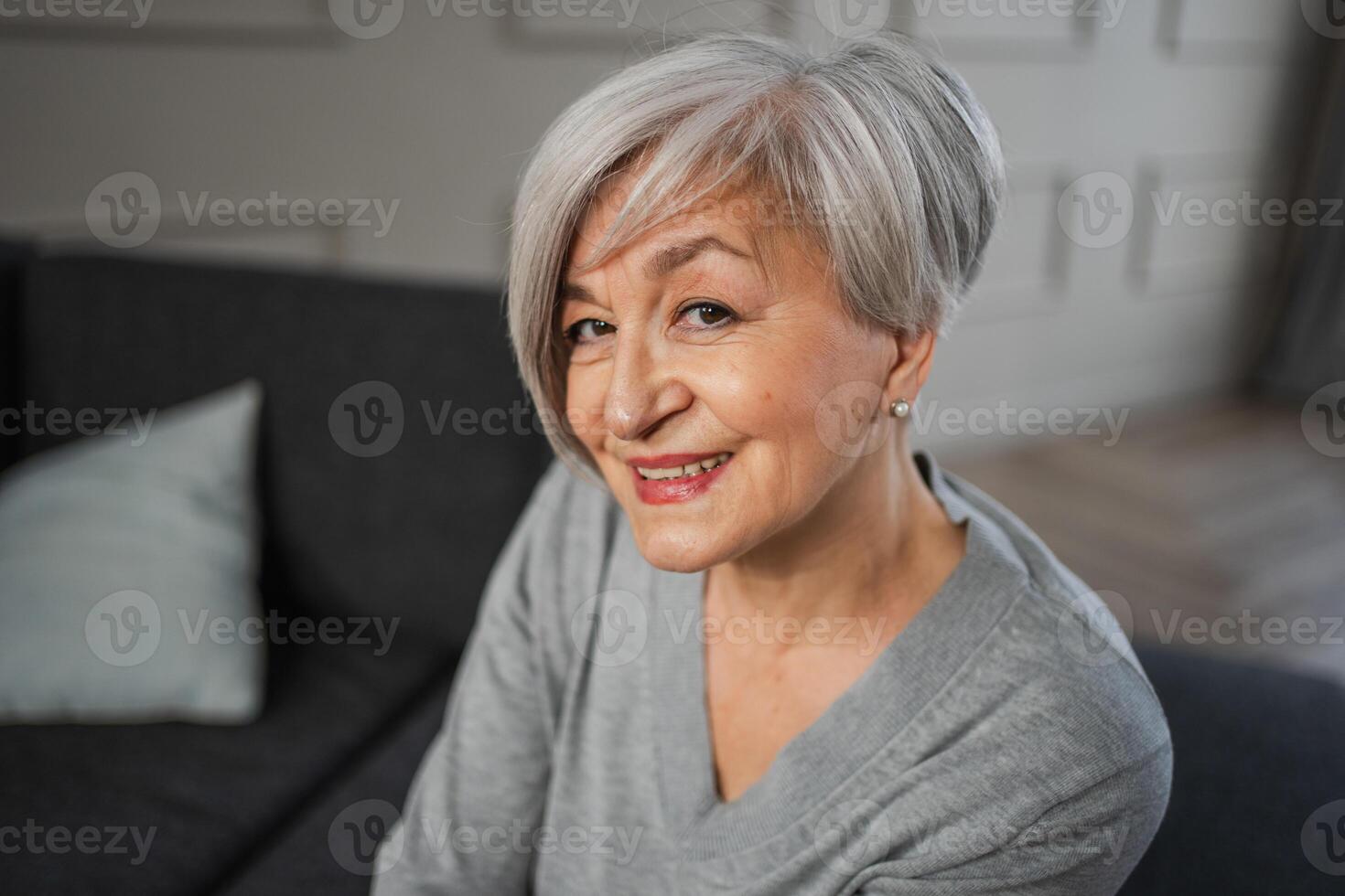 portrait de sur de soi élégant européen milieu vieilli Sénior femme. plus âgée mature Années 60 Dame souriant à maison. content attrayant Sénior femelle à la recherche caméra proche en haut visage photo du visage portrait. content gens