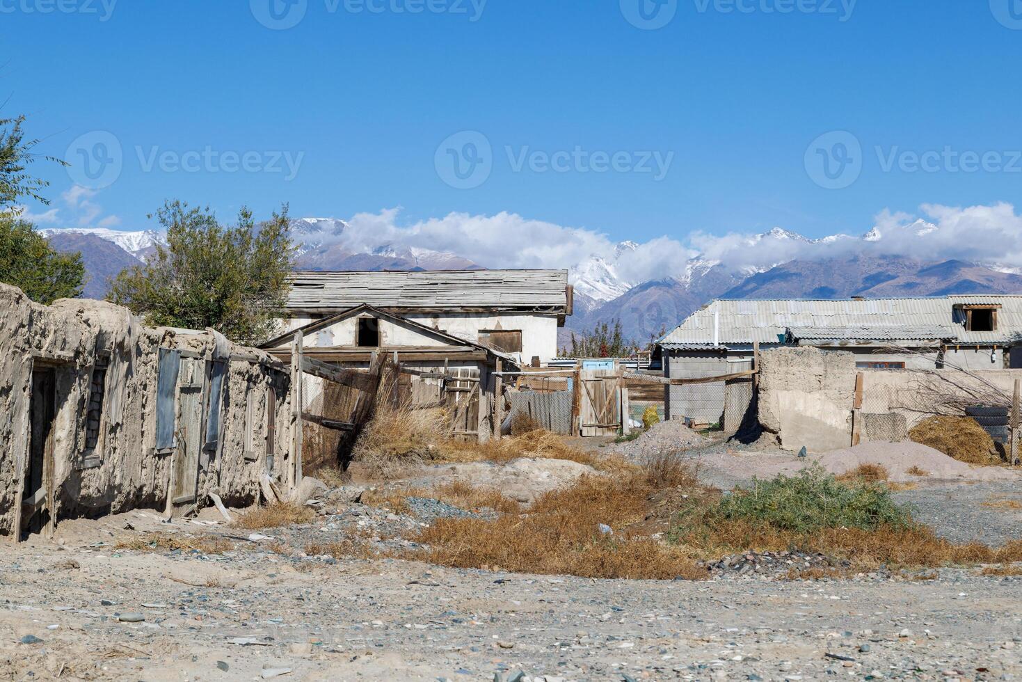 rustique kirghize Maisons dans de face de neige couvert montagnes dans le Contexte photo