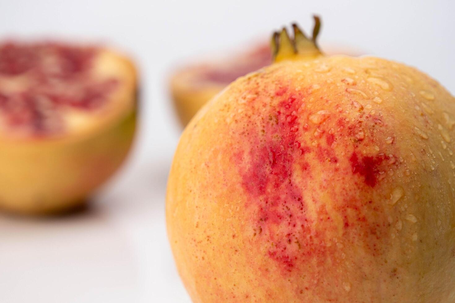 Frais Grenade avec jus éclaboussure et Grenade Couper dans moitié comme Contexte. mûr fruit est une en bonne santé aliments. photo