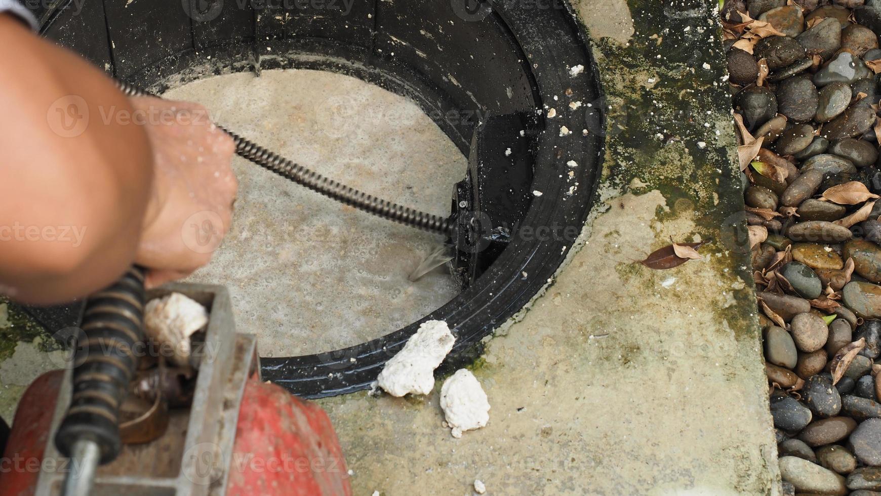 nettoyage des canalisations. plombier réparant le bac à graisse bouché avec tarière photo