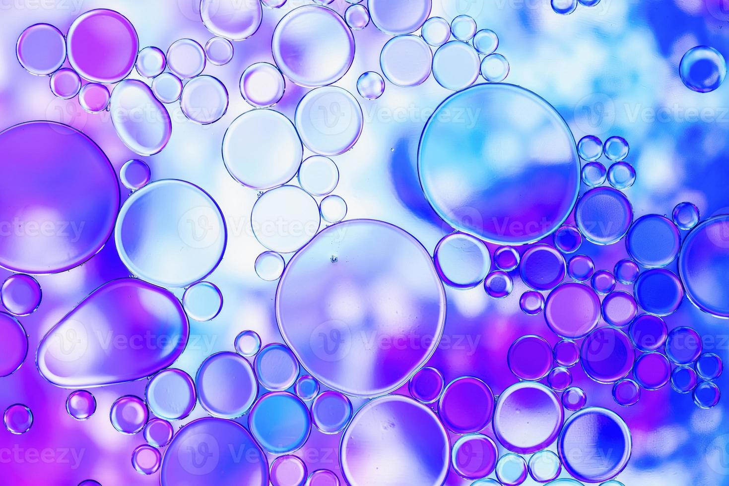 bulles d'huile bleues et violettes dans l'eau avec motif abstrait photo