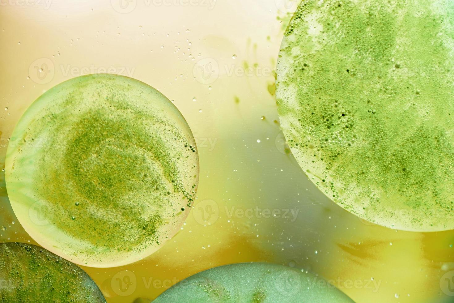 abstrait avec des bulles d'huile sur la surface de l'eau jaune et verte photo