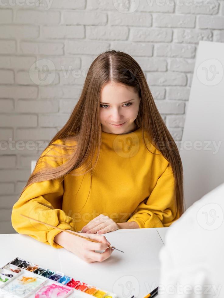 artiste féminine peignant une image à l'aquarelle en studio photo