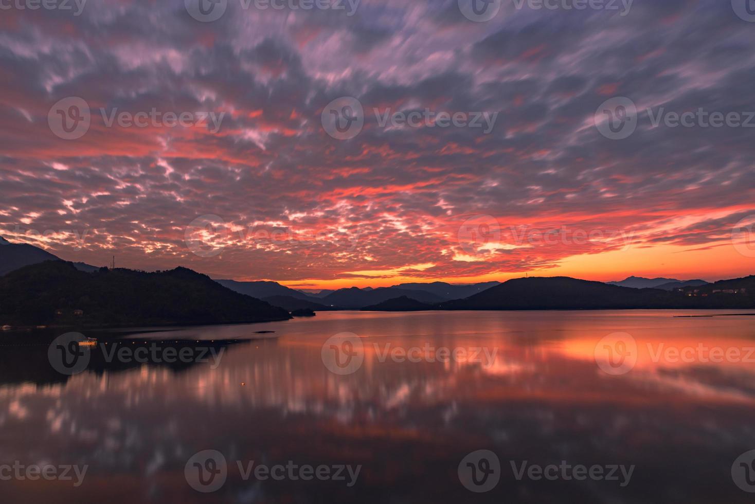 le lac du soir reflétait la lueur du coucher du soleil et les montagnes photo