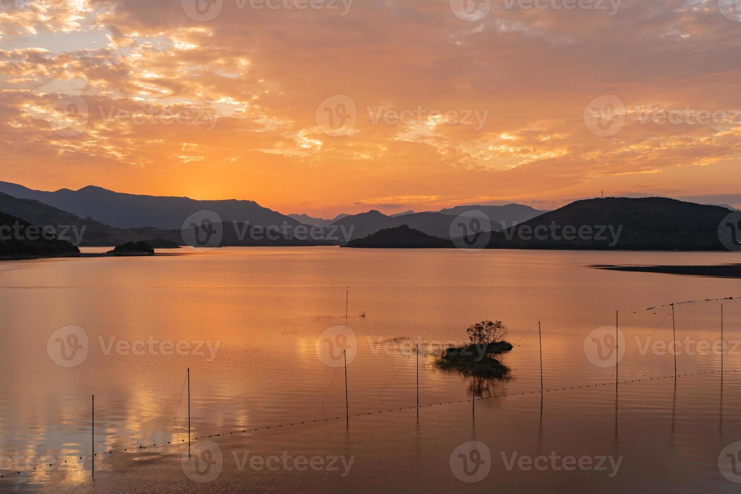 le lac du soir reflétait la lueur du coucher du soleil et les montagnes photo