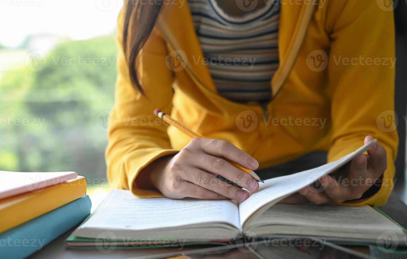 les étudiants lisent des livres et prennent des notes pour la préparation des examens. photo