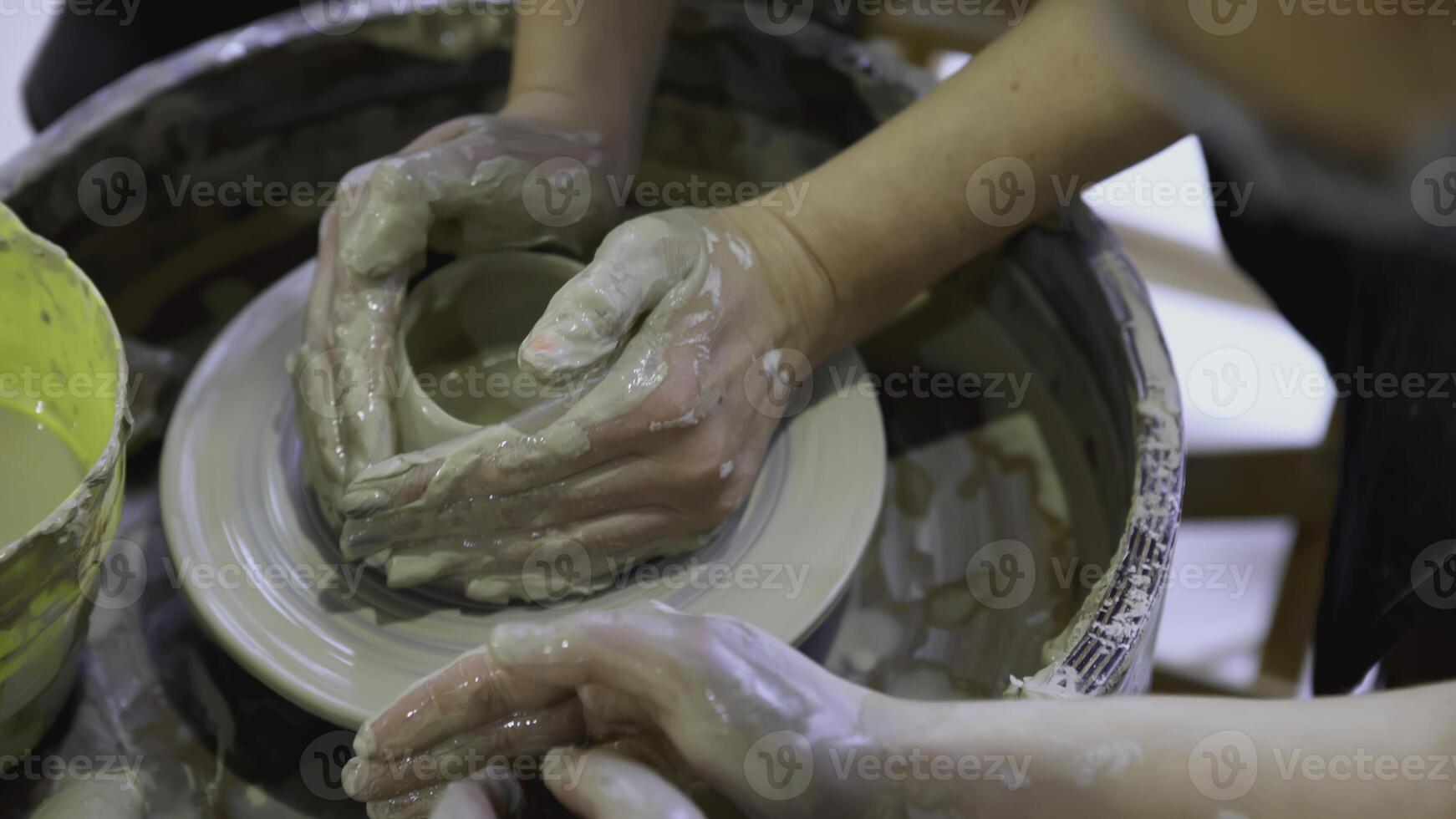 le mains de une enfant sur une potier roue sculpter une pot. art. le mains de un adulte et une enfant dans fermer sont engagé dans poterie à le Festival photo