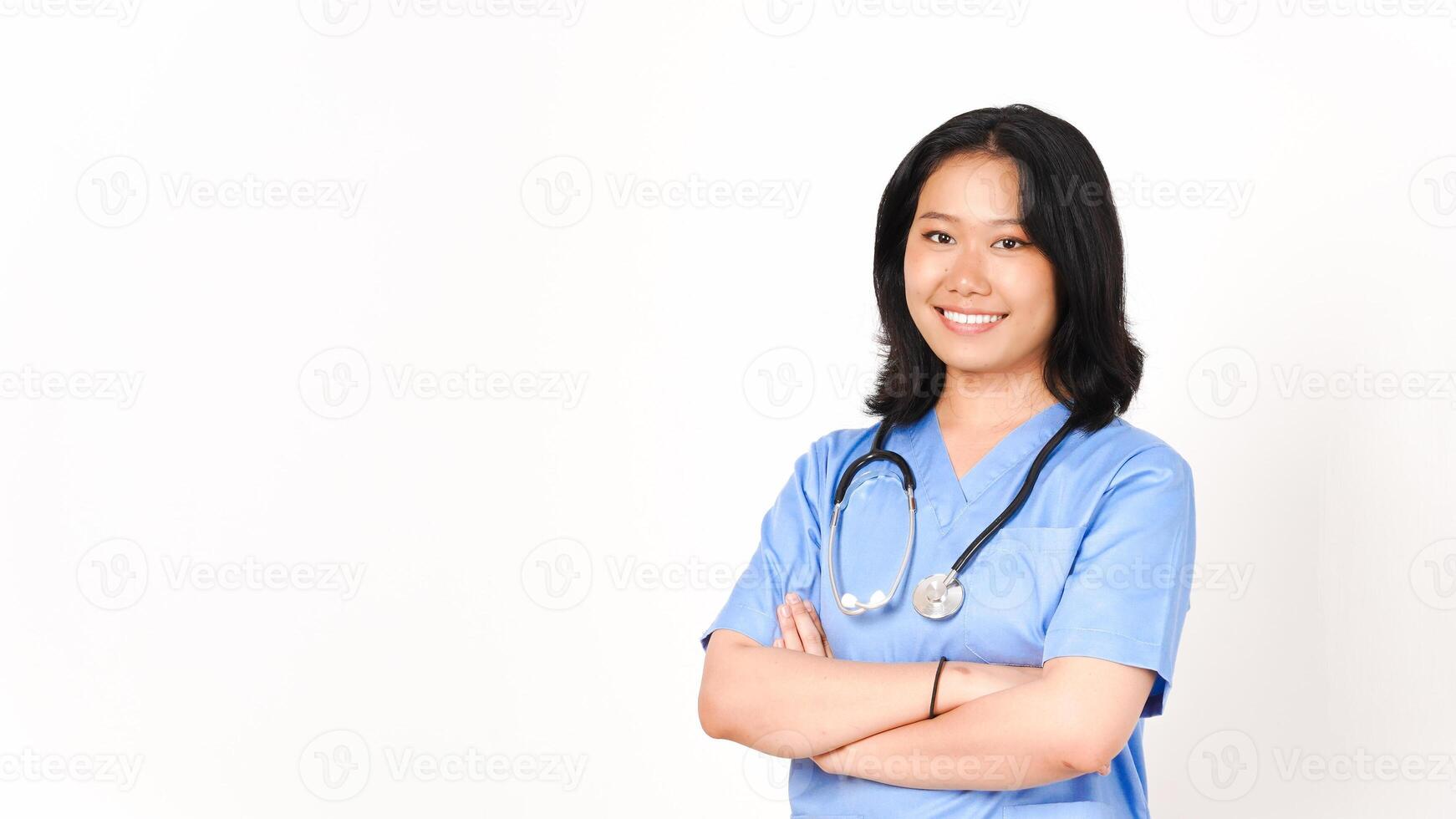 Jeune asiatique femelle médecin pliant bras souriant et à la recherche à caméra isolé sur blanc Contexte photo