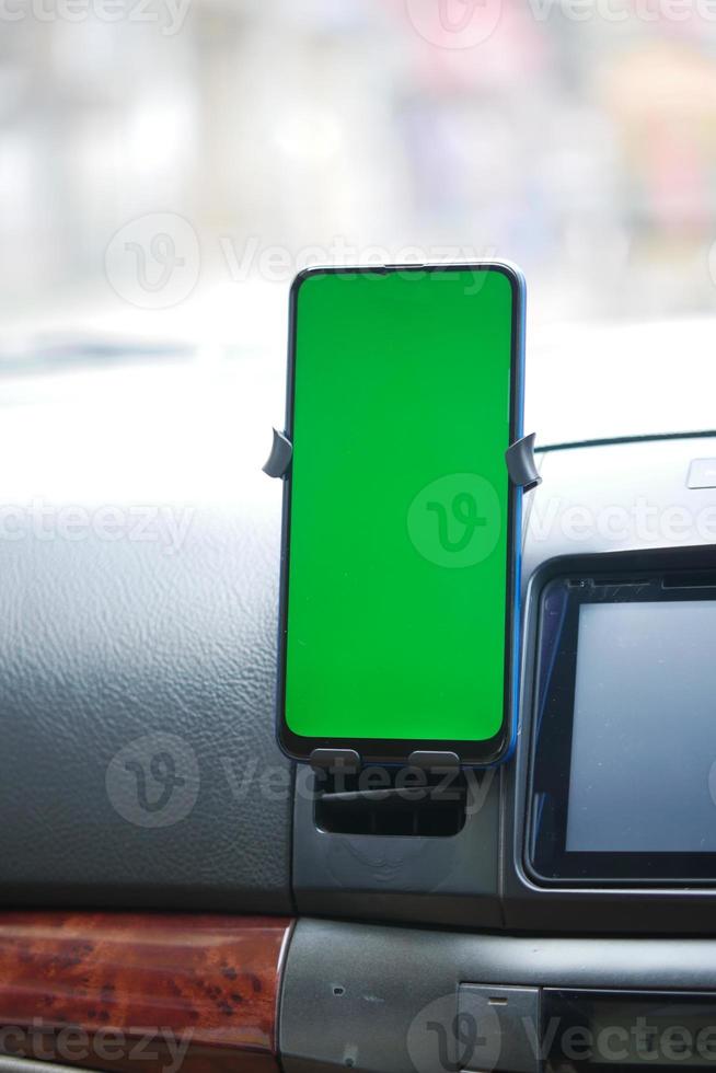 téléphone intelligent avec écran vert sur le tableau de bord de la voiture photo