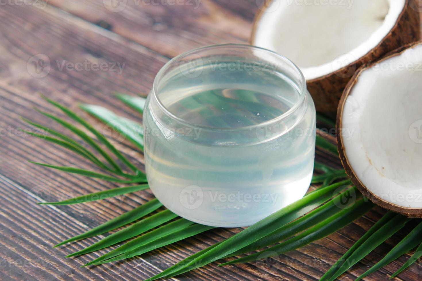 tranche de noix de coco fraîche et bouteille d'huile sur une table photo