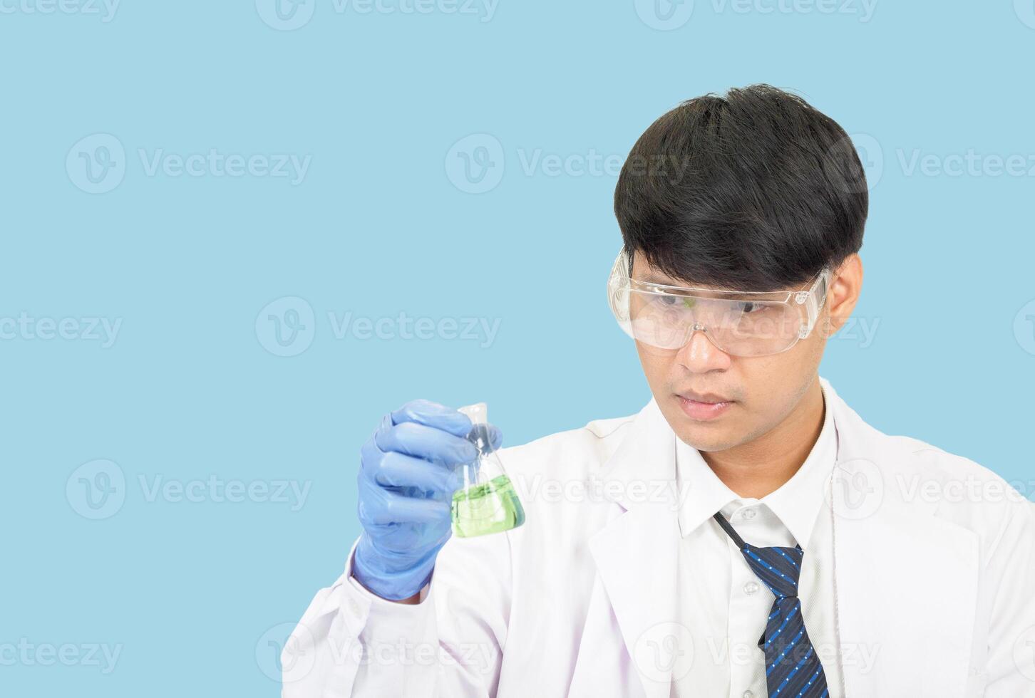 asiatique homme étudiant scientifique dans réactif mélange laboratoire dans une science recherche laboratoire avec tester tubes de divers tailles. sur le sol dans laboratoire chimie laboratoire bleu Contexte. photo