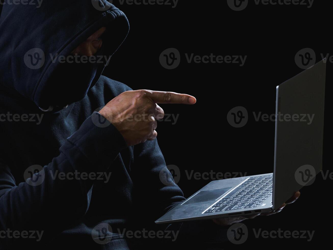 portrait pirate espion homme un la personne dans noir sweat à capuche séance sur table à la recherche ordinateur portable utilisé s'identifier mot de passe attaque Sécurité à Les données numérique l'Internet réseau système nuit foncé Contexte copie espace photo
