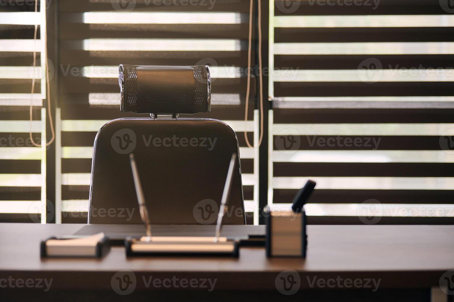 lieu de travail de bureau d'affaires. la lumière du soleil sur le lieu de travail pour le chef, le patron ou d'autres employés. table et chaise confortable. lumière à travers les stores à demi ouverts photo