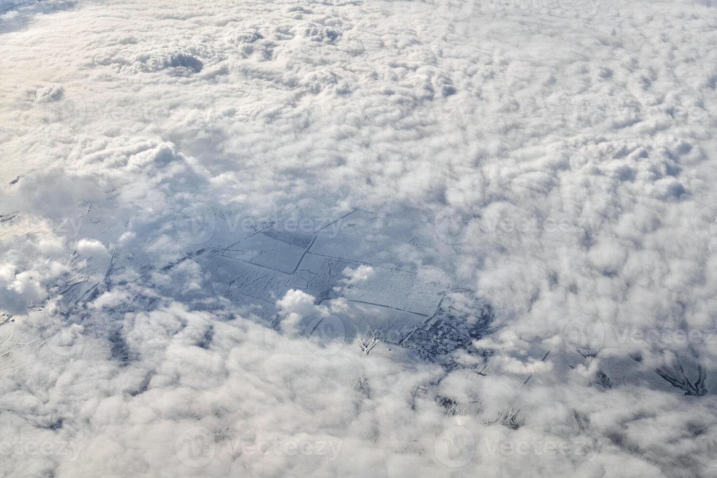 vue à couper le souffle sur les nuages depuis la fenêtre de l'avion, d'épais nuages bleus blancs ressemblent à de la mousse souple photo