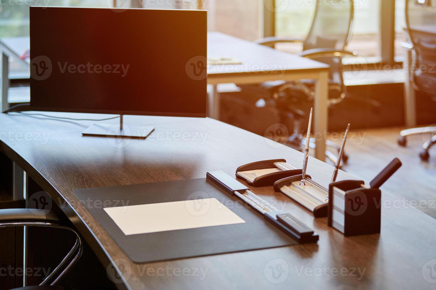 lieu de travail de bureau moderne. surveiller sur la table des employés. lieu de travail professionnel pour chef ou patron. soleil du matin. photo