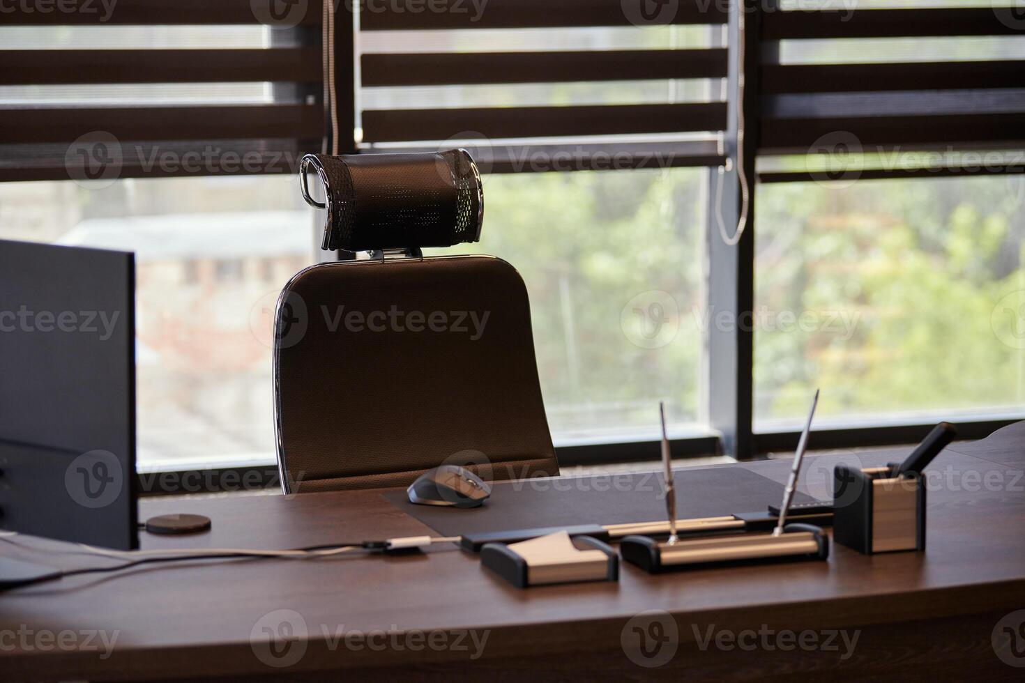 lieu de travail de bureau d'affaires. lieu de travail pour le chef, le patron ou d'autres employés. table et chaise confortable. lumière à travers les stores à demi ouverts photo