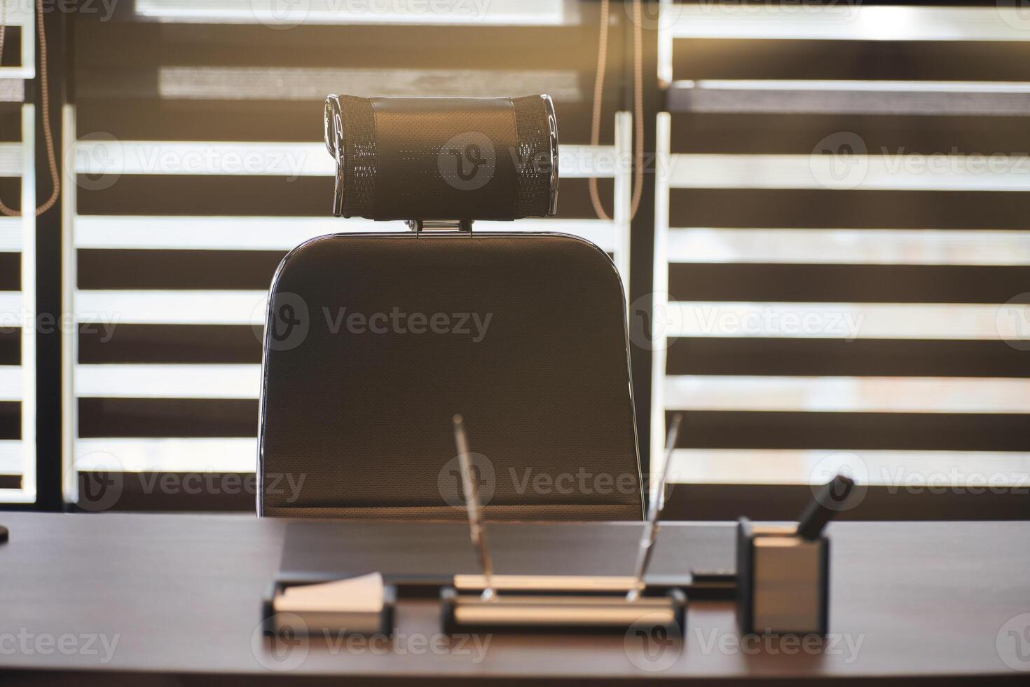 lieu de travail de bureau d'affaires. la lumière du soleil sur le lieu de travail pour le chef, le patron ou d'autres employés. table et chaise confortable. lumière à travers les stores à demi ouverts photo