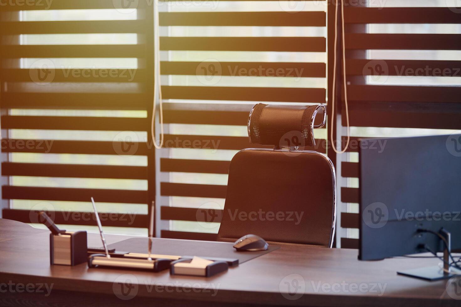 lieu de travail de bureau d'affaires. la lumière du soleil sur le lieu de travail pour le chef, le patron ou d'autres employés. table et chaise confortable. lumière à travers les stores à demi ouverts photo