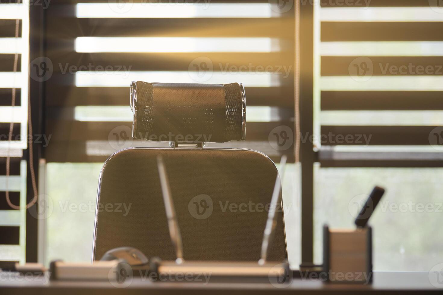 lieu de travail de bureau d'affaires. la lumière du soleil sur le lieu de travail pour le chef, le patron ou d'autres employés. table et chaise confortable. lumière à travers les stores à demi ouverts photo