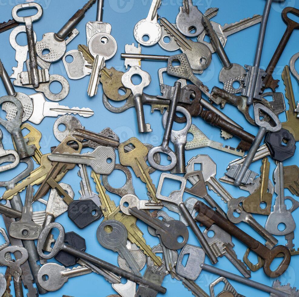 clés définies sur fond bleu. clés de serrure de porte et coffres-forts pour la sécurité de la propriété et la protection de la maison. différents types de clés anciennes et nouvelles. photo