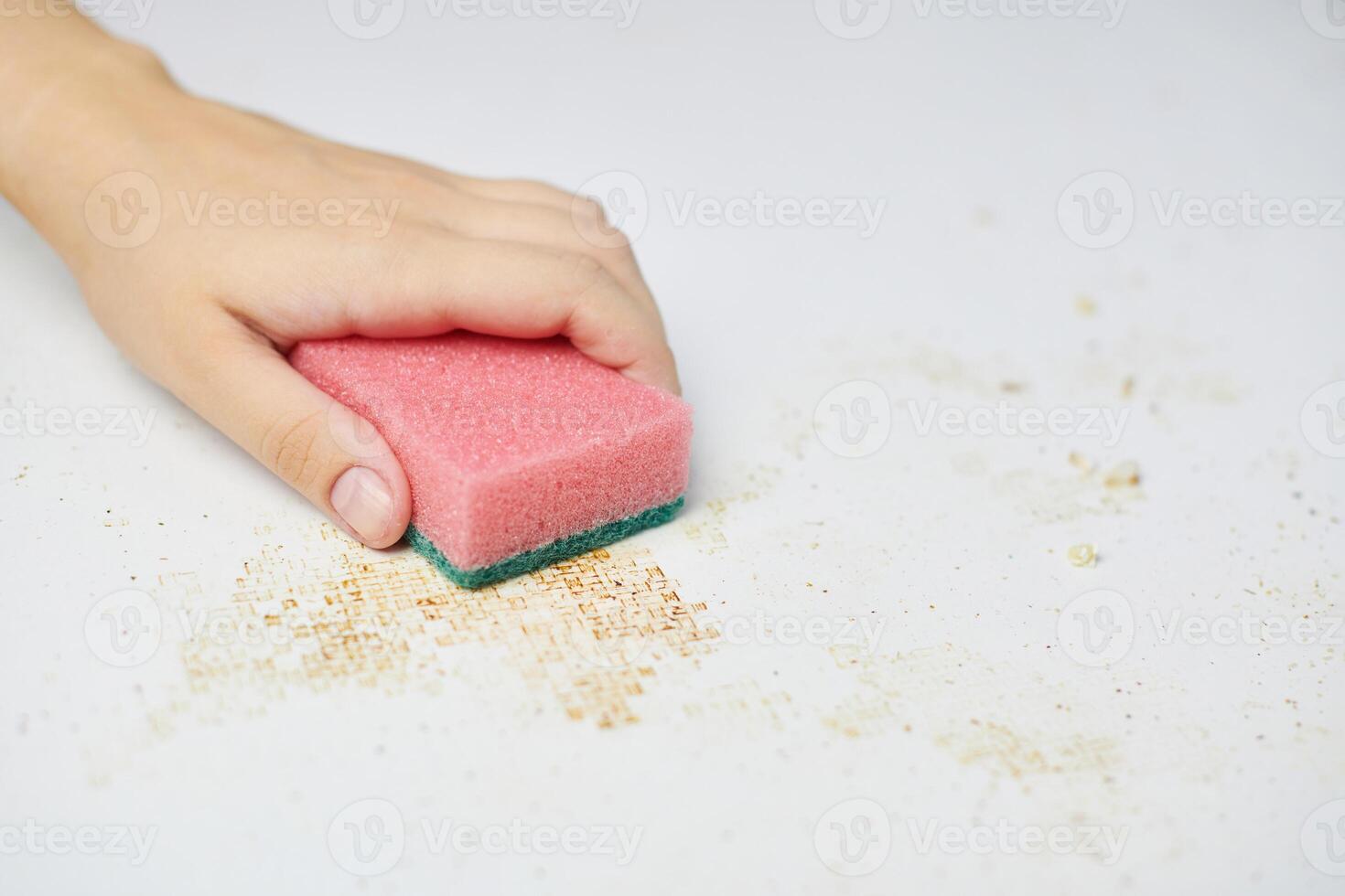 nettoyer la table de la cuisine. l'éponge rose dans la main de la femme enlève la saleté, les miettes de pain et les restes. tâches ménagères photo