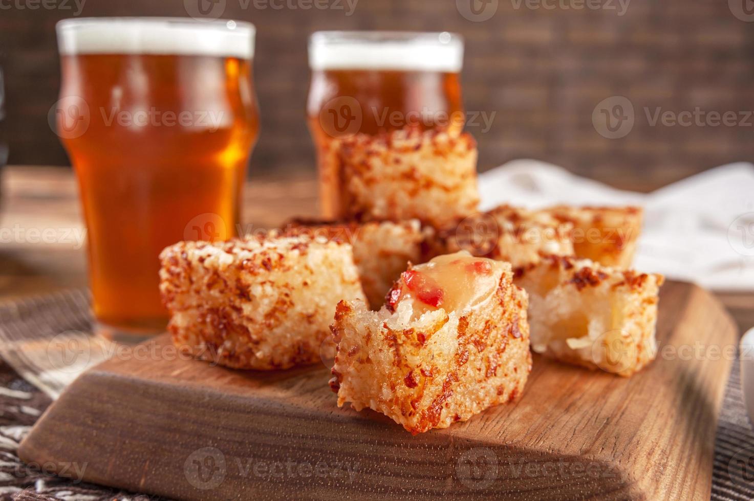 dés de tapioca avec gelée de poivre et verres de bière sur une planche à découper en bois - gros plan. photo