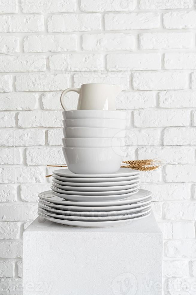pile de plats et vaisselle en céramique blanche sur fond de mur de briques blanches photo